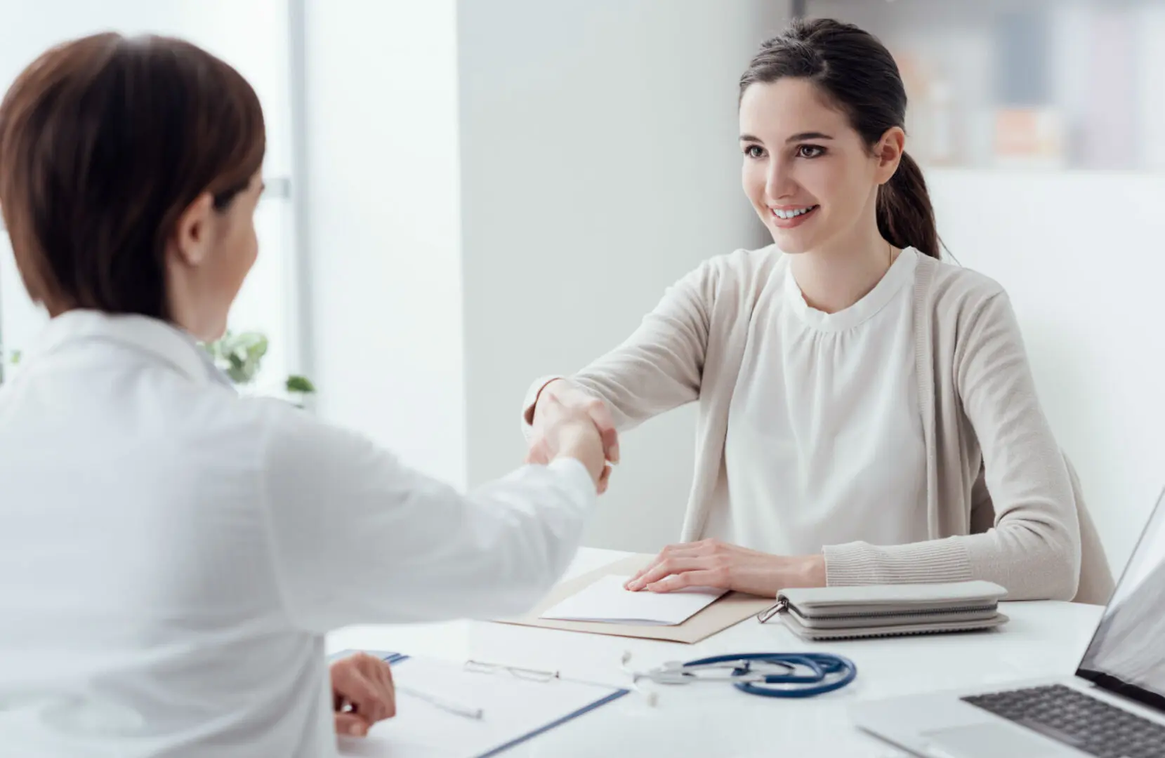 a woman shaking hands with a doctor